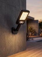 Foco solar LED negro con sensor Nido instalado en un muro exterior
